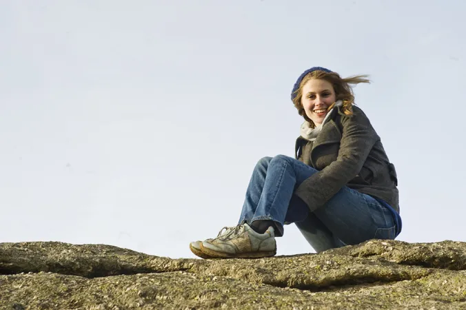 Young woman sitting on a rocky surface