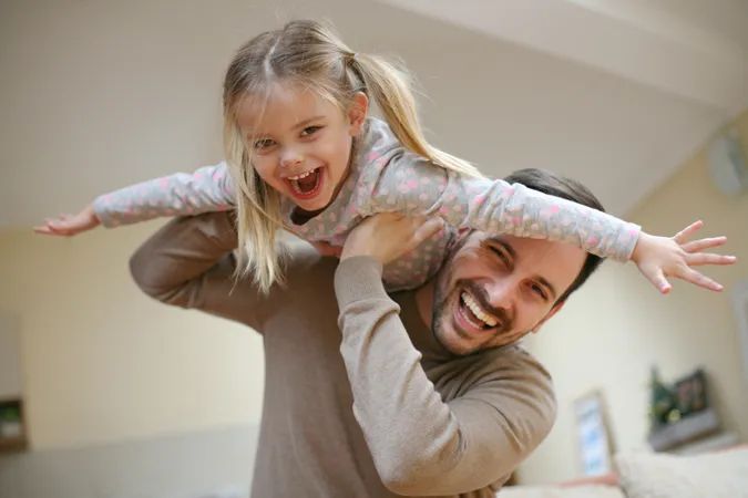 Father playing with his little girl who is on his shoulders