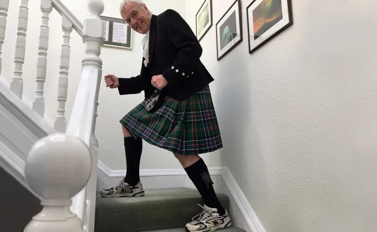 Moderator climbing stairs wear kilt and trainers