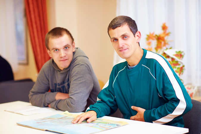 Two men sitting at a table with a map