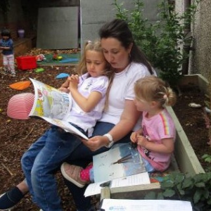 Two young girls being read to