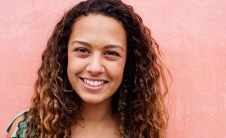 Young woman with long curly hair smiling