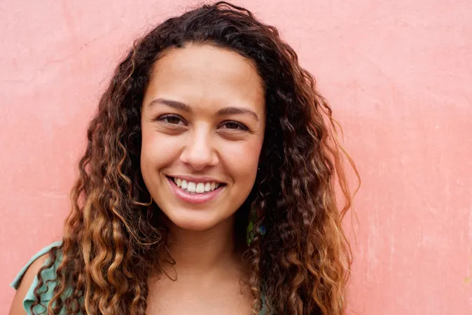 Young woman with long curly hair smiling
