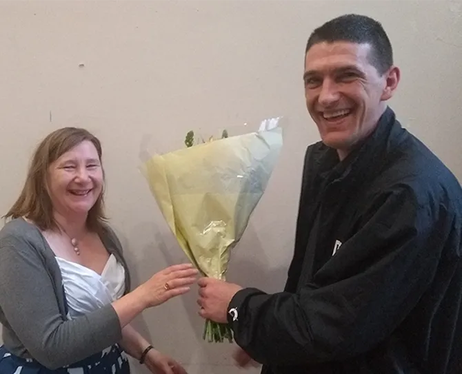 Rehab, addiction, recovery, volunteer - man and woman exchanging flowers