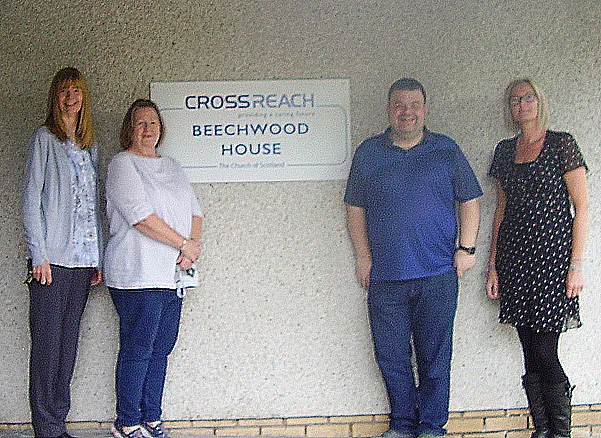Beechwood staff standing in front of sign