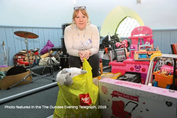 Lucie Conway sitting with gifts for Toy Recycle