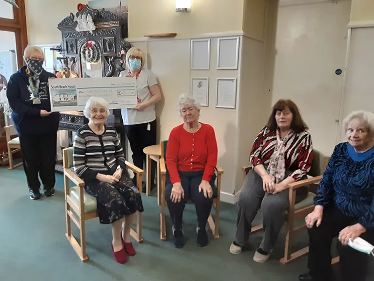 Lilian presents a cheque to residents and staff at South Beach House, Ardrossan 